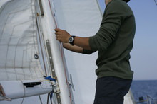 Man Hoisting A Sail