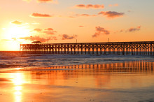 Atlantic Ocean Sunrise Background. Golden Sunrise Over The Ocean. Atlantic Ocean Landscape With A Wooden Pier In Myrtle Beach Area, South Carolina, USA.