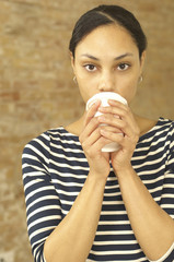 Serious young woman holding plastic cup