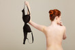 © anetlanda - Naked woman holds black bra in hand