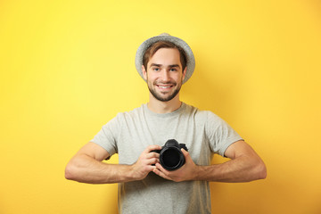 Handsome young photographer on color background