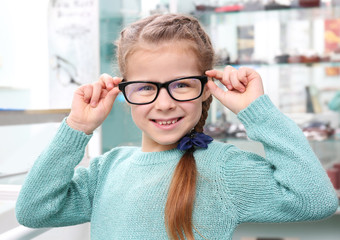 Poster - Cute little girl with new glasses in shop