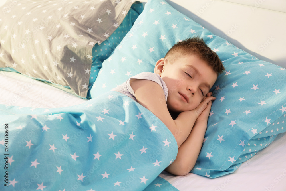 Adorable boy sleeping in bed