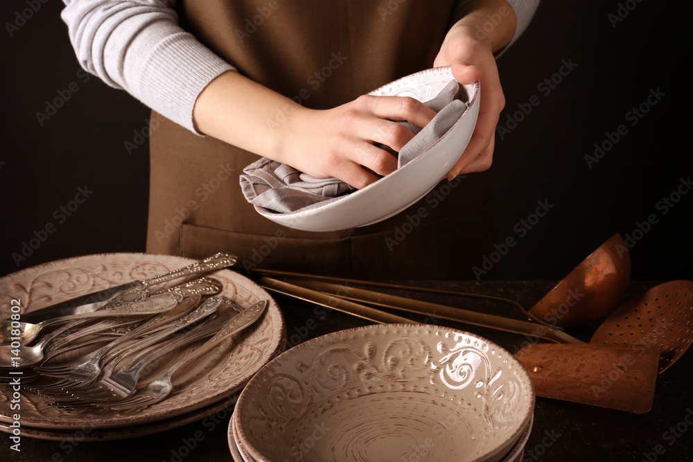 Woman wiping plate with napkin, closeup