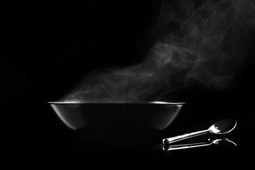 Wall Mural - Steaming bowl on black background