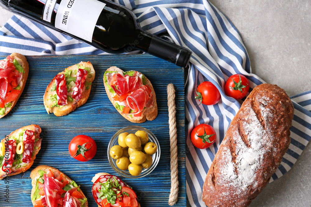 Wooden board with tasty bruschetta and  wine on light background