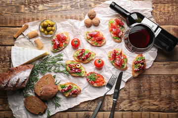 Tasty bruschetta served with wine on wooden background