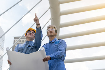 Engineer and Architect working at Construction Site with blueprint