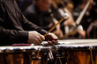 Hands musician playing the timpani in the orchestra closeup in dark colors