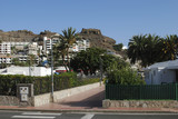 Fototapeta Niebo - City view with white buildings in the mountains. Puerto Rico, Gran Canaria, Spain.