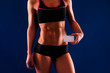 © VlaDee - Fitness girl showing business card . Fitness woman isolated on blue background.