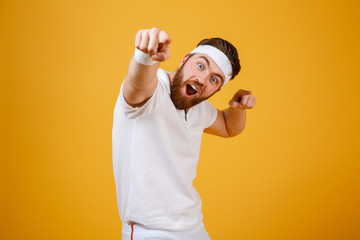 Wall Mural - Happy screaming sportsman pointing at camera