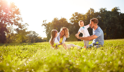 Male and female playing with children outside.