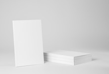 Real Paperback White Book Next To A Stack Of Books On A Gray Background