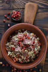 Wall Mural - Ceramic bowl with pilaf on a rustic wooden background, high angle view