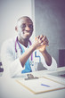 © lenets_tan - Young african doctor working on laptop at desk