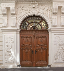 Old, antique, wooden door surrounded by ornamental wall.