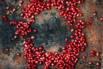 Wall Mural - Pomegranate seeds frame over black rustic surface.