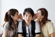 © amanaimages - Young women whispering to young man