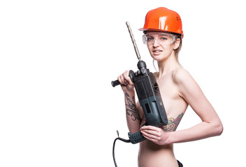 Young sexy nude woman holding a construction drill. Seductive female builder worker in hard hat and construction glasses. Isolated on white background. Copy space.