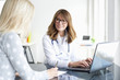 © sepy - Doctor and her patient. Shot of a middle aged smiling female doctor sitting in front of laptop and meeting with her patient.