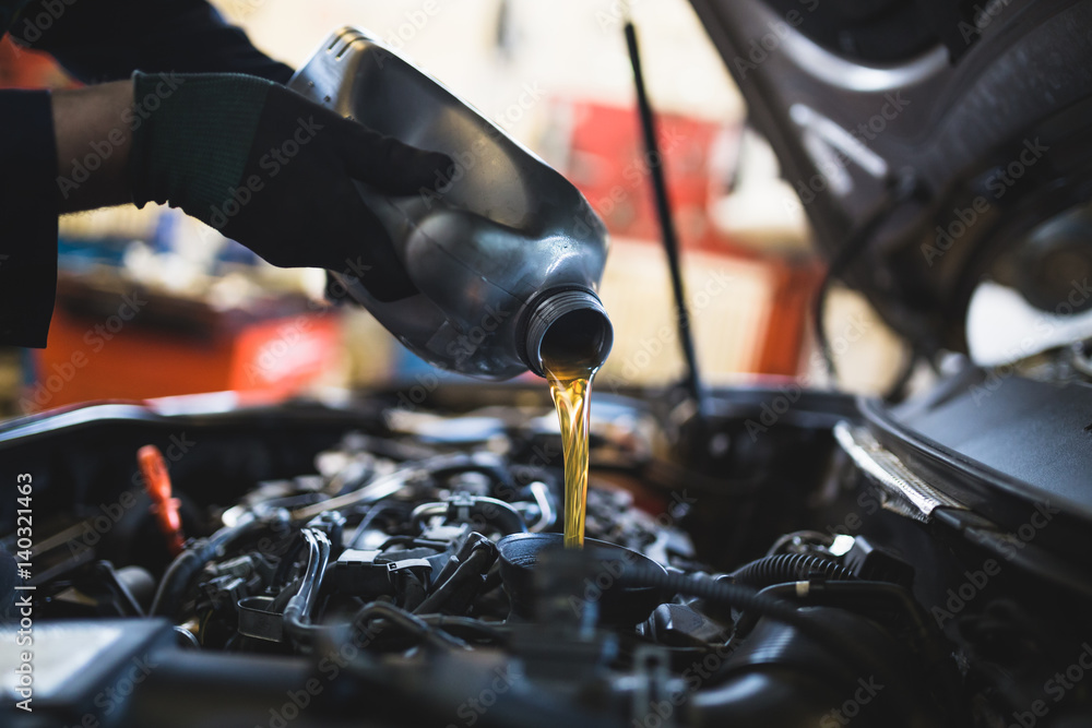 Close up hands of unrecognizable mechanic doing car service and maintenance.