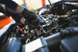 © Dusko - Close up hands of unrecognizable mechanic doing car service and maintenance.