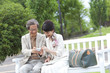 © amanaimages - Mature couple looking at digital camera