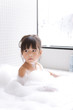 © amanaimages - Girl taking a bubble bath