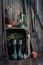 An Old Rustic Shed With Garden Tools And Clay Pots