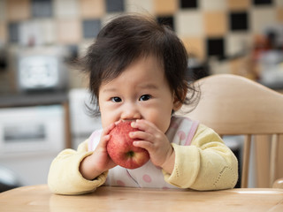 Wall Mural - baby girl eating apple