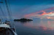Indonesian Sunset From  A Schooner Sailboat. Sailing Through The Raja Ampat Archipelago On A Traditional Phinisi Schooner During A Glorious Sunset.  