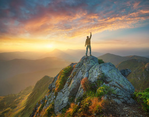 Wall Mural - Silhouette of a champion on mountain peak. Active life concept