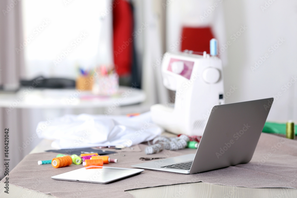 Fashion designer workplace with laptop on table