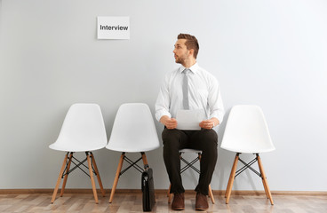 Canvas Print - Young man waiting for interview indoors