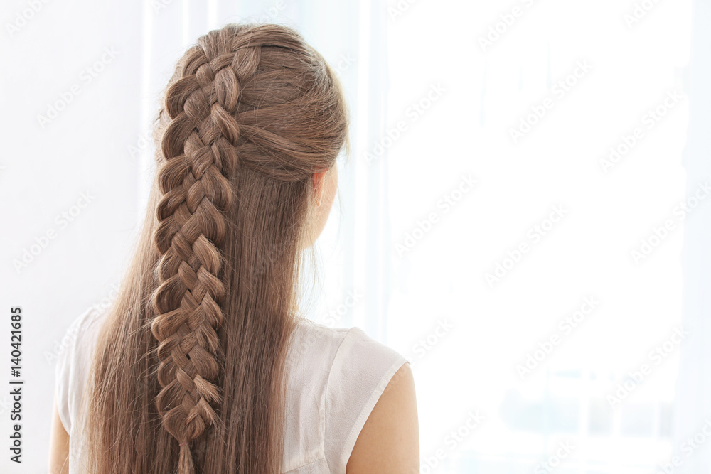 Young beautiful woman with nice braid hairstyle on light background - obrazy, fototapety, plakaty 