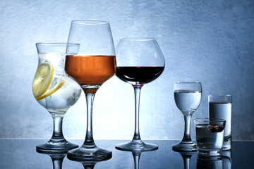 Wall Mural - Different glasses of wine and spirits on color background