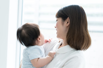 赤ちゃんを抱いた女性看護師