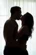 © DenisProduction.com - Couple kissing on window background. People hugging in the dark. Don't restrain the passion.