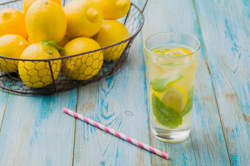 Wall Mural - lemonade with mint on rocks served in a glass with a straw