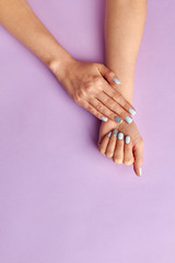 Fotomurales - Women's manicure on purple background.
