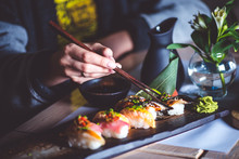 Man Eating Sushi Set With Chopsticks On Restaurant