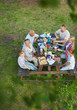© pressmaster - Happy family sitting by served table on summer day
