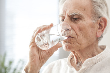 Portrait elderly man drinking water 