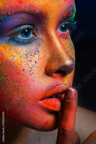 Model with art make-up posing on dark background