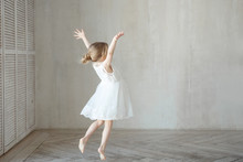 A Little Girl Dancing In A Room In A Beautiful Dress