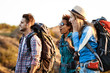 © Cookie Studio - Young cheerful travelers with backpacks surprised, smiling, walking in canyon.