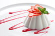  Panna cotta dessert with strawberries on a white plate . Close up 