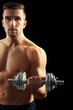 © Africa Studio - Sporty man doing exercises with dumbbell on black background