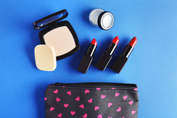 Wall Mural - Cosmetic bag and makeup products on color   background